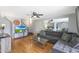 Bright living room with L-shaped sofa, wood floors, and a view into the dining area at 8225 N 34Th Dr, Phoenix, AZ 85051