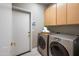 Functional laundry room with washer, dryer, and ample cabinets at 8260 E Mohawk Ln, Scottsdale, AZ 85255