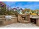 Outdoor kitchen with grill, fireplace and stone counters at 9270 E Thompson Peak Pkwy # 335, Scottsdale, AZ 85255