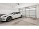 Two-car garage with white Tesla and polished concrete floor at 9316 S 39Th Dr, Laveen, AZ 85339