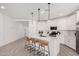 Modern white kitchen with center island and breakfast bar at 9316 S 39Th Dr, Laveen, AZ 85339