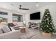 Bright living room with sectional sofa, large TV, and Christmas tree at 9316 S 39Th Dr, Laveen, AZ 85339