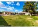 Landscaped backyard with grassy area and large trees at 9613 W Camino De Oro Dr, Peoria, AZ 85383