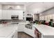 Modern kitchen with white cabinets, island, and stainless steel sink at 9613 W Camino De Oro Dr, Peoria, AZ 85383