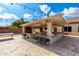 Covered patio with outdoor kitchen, bar seating, and string lights at 9613 W Camino De Oro Dr, Peoria, AZ 85383