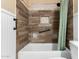 Bathroom with brown tile, built-in shelves, and a tub at 10611 W Caron Dr, Sun City, AZ 85351