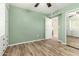 Bedroom with wood-look tile, built-in storage, and a mirrored closet at 10611 W Caron Dr, Sun City, AZ 85351