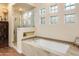 Spa-like bathroom with soaking tub, glass shower, and granite vanity at 10760 E Caribbean Ln, Scottsdale, AZ 85255