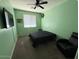 Bright bedroom with a large TV, window blinds, and comfortable seating at 11644 W Redfield Rd, El Mirage, AZ 85335