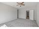 Well-lit bedroom featuring a ceiling fan and additional door at 15113 W Cactus Ridge Way, Surprise, AZ 85374