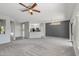 Bright living room with grey walls, carpet flooring, and a view of the kitchen at 15113 W Cactus Ridge Way, Surprise, AZ 85374