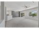 Open living area with grey accent wall, carpet flooring, and a view of the kitchen at 15113 W Cactus Ridge Way, Surprise, AZ 85374