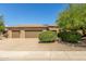Three-car garage and front yard with drought-tolerant landscaping at 17311 N Havasupai Dr, Surprise, AZ 85374