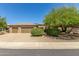 Tan 3-car garage home with desert landscaping at 17311 N Havasupai Dr, Surprise, AZ 85374