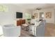 Open living area with a gray sofa, white armchairs, and a large TV at 1934 E Monte Vista Rd, Phoenix, AZ 85006