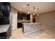 Modern kitchen with dark cabinetry, granite counters, and large island at 20226 N 260Th Dr, Buckeye, AZ 85396