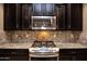 Kitchen features gas cooktop, microwave, and granite countertops at 20226 N 260Th Dr, Buckeye, AZ 85396