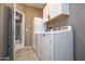 Bright laundry room with white appliances and cabinets at 20226 N 260Th Dr, Buckeye, AZ 85396