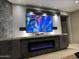 Living room with a large TV above a modern fireplace and cabinets at 20226 N 260Th Dr, Buckeye, AZ 85396