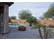 Inviting backyard oasis featuring a sparkling pool, lush landscaping, and a serene, private outdoor living space at 20226 N 260Th Dr, Buckeye, AZ 85396