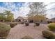 Landscaped backyard with gravel, mature trees, and a covered patio at 22568 W Gardenia Dr, Buckeye, AZ 85326