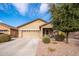 One-story house with tan exterior, two-car garage, and landscaping at 22568 W Gardenia Dr, Buckeye, AZ 85326