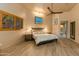 Main bedroom with wood flooring, a king-size bed, and access to the ensuite bathroom at 25555 N Wrangler Rd, Scottsdale, AZ 85255