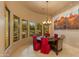 Elegant dining room with a round table, red chairs, and large windows overlooking the backyard at 25555 N Wrangler Rd, Scottsdale, AZ 85255