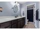 Clean bathroom with dark brown vanity, oval mirror, and shower at 25584 W Crown King Rd, Buckeye, AZ 85326