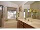 Well-lit bathroom features dual sinks, a soaking tub by a window, and a neutral color palette at 2625 N 110Th Dr, Avondale, AZ 85392