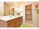 Bright bathroom featuring a dual sink vanity, large mirror, and a separate walk-in closet at 2625 N 110Th Dr, Avondale, AZ 85392