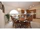 Warm dining room featuring a wooden table, chairs, and a charming arched window for natural light at 2625 N 110Th Dr, Avondale, AZ 85392