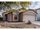 Beige house with a two-car garage and desert landscaping at 2625 N 110Th Dr, Avondale, AZ 85392