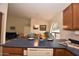 Modern kitchen featuring an island, wooden cabinetry, and open access to other living areas at 2625 N 110Th Dr, Avondale, AZ 85392