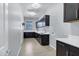 Bright laundry room with dark cabinetry, a sink, and light tile floors at 3532 E Penedes Dr, Gilbert, AZ 85298