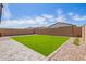 Artificial turf backyard with stone border and string lights at 35321 W Santa Monica Ave, Maricopa, AZ 85138