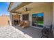 Covered patio with comfortable seating, grill, and access to backyard at 35321 W Santa Monica Ave, Maricopa, AZ 85138