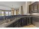 Kitchen wet bar with granite countertop, wine cooler, and dark wood cabinets at 36549 N Porta Nuova Rd, Scottsdale, AZ 85262