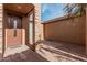 Front entry with a brown wood door and brick columns at 42432 W Abbey Rd, Maricopa, AZ 85138