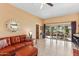 Living room with leather sofas and view of patio and kitchen at 9711 W Briarwood Cir, Sun City, AZ 85351