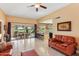 Living room with leather sofas, patio view, and golf course view at 9711 W Briarwood Cir, Sun City, AZ 85351