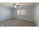 Bedroom with neutral carpeting, window with curtains, and a ceiling fan at 9841 N Balboa Dr, Sun City, AZ 85351