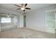 Spacious bedroom with mirrored closet doors, neutral carpeting, and ceiling fan at 9841 N Balboa Dr, Sun City, AZ 85351