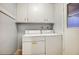 Bright laundry room with washer, dryer, and ample cabinets at 9841 N Balboa Dr, Sun City, AZ 85351