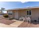 Tan single story home with small front patio and seating at 10518 W Oakmont Dr, Sun City, AZ 85351