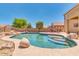 Relaxing kidney-shaped pool surrounded by rocks and landscaping at 12503 S 175Th Ave, Goodyear, AZ 85338