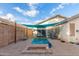 Backyard patio with seating area, shade umbrella, and grill at 12907 W Sharon Dr, El Mirage, AZ 85335