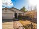 Tan two-car garage home with walkway and landscaping at 12907 W Sharon Dr, El Mirage, AZ 85335