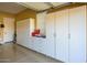 Garage with built-in white cabinets and storage at 13105 W Micheltorena Dr, Sun City West, AZ 85375