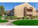 Tan two-story condo building with grassy areas and walkways at 14203 N 19Th Ave # 1051, Phoenix, AZ 85023